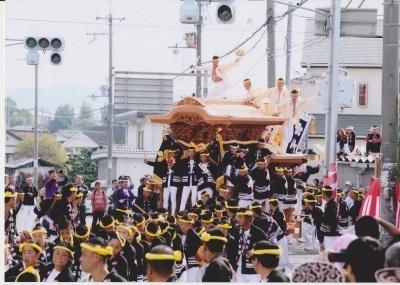 黄色のねじり鉢巻き姿の人達が小谷地車を引いている写真