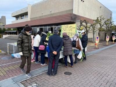 くまとり野菜軽トラ市で軽トラの荷台の野菜をたくさんの人がみている写真