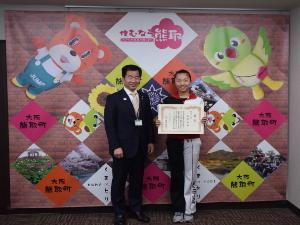 賞状を持つ武市萌さんと、その横に立つ町長の写真