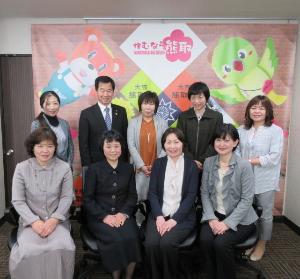 婦人会の女性8名と、町長が笑顔で並んでいる集合写真