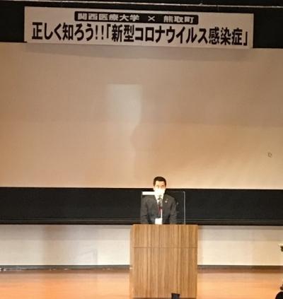 「正しく知ろう!!新型コロナウイルス感染症」と書かれた横断幕の前の壇上で町長が話をしている写真
