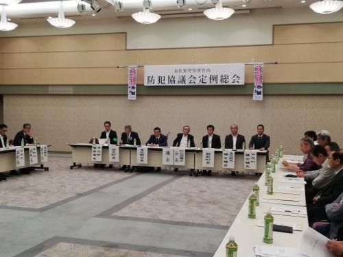 参加者がコの字型に並べられた机を前に椅子に座っている防犯協議会定例総会の写真