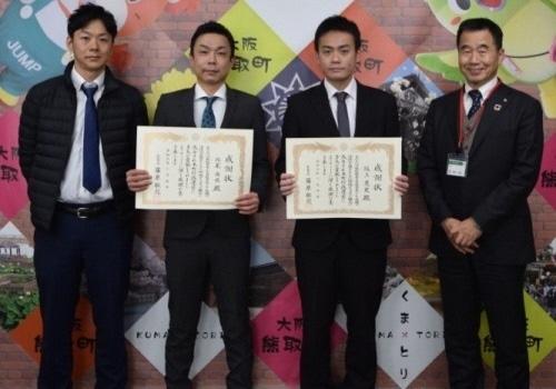 町長と感謝状を持った2人の男性、ダウンジャケット姿の男性1名が並んで写っている写真