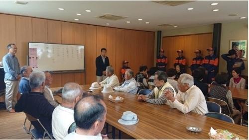 ホワイトボードの横で立って話す町長と、座って聞く参加者の写真