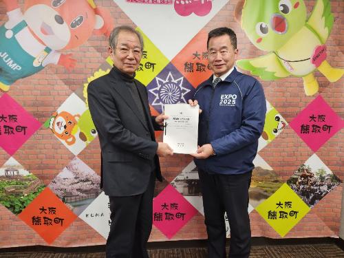 子ども・子育て会議の山本健慈会長から熊取町こども計画（案）を受け取る藤原町長の写真