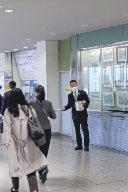 熊取駅で広報くまとり4月号を配布する町長