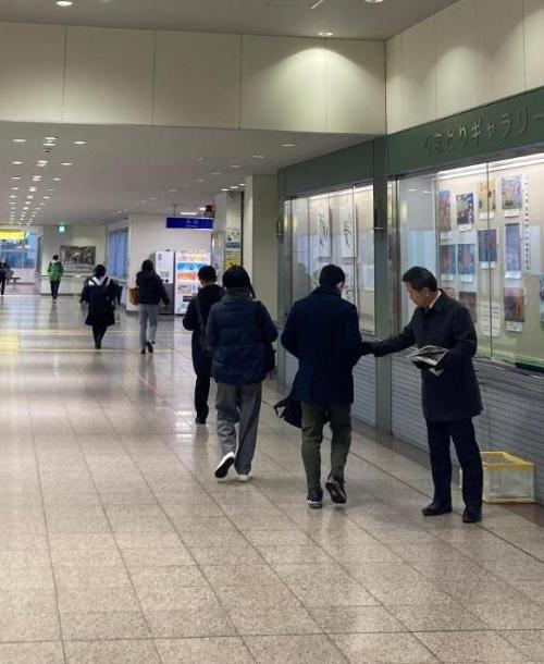 熊取駅で広報くまとり3月号を配布する藤原町長の写真