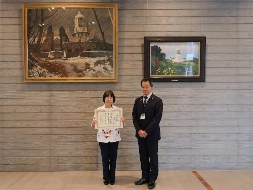 寄贈された絵画の前で記念撮影する徳野さんと藤原町長
