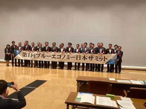 横断幕を持って記念撮影している様子