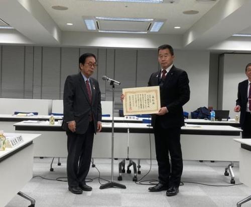 受け取った賞状を持ち、大阪府庁村長会の田代会長と記念撮影する藤原町長