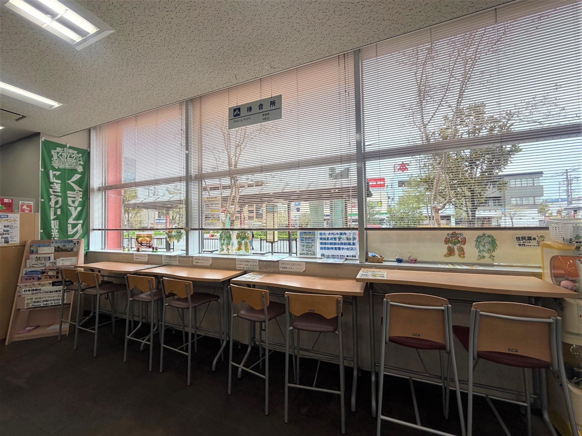 窓に向かって机と椅子が設置された待合いカウンターの写真