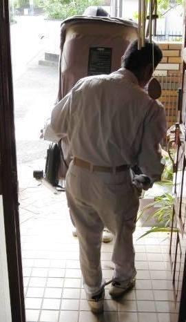 作業着を着た男性スタッフが、家の玄関から運び出しサポートを行っている様子の写真