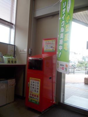 公共施設の入口に設置されている、赤色で口が広い回収ボックスの写真