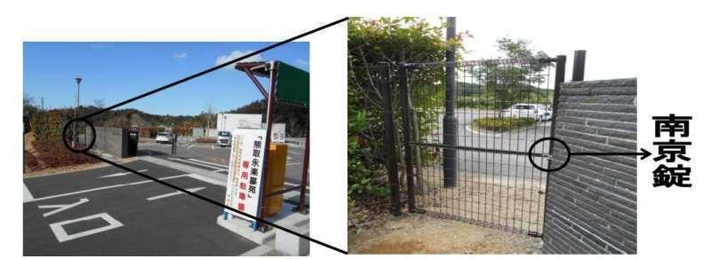左：熊取永楽墓苑の専用駐車場の左側を黒丸で示し、右：黒丸部分をさらに拡大して通用門の扉の南京錠を黒丸で示している写真
