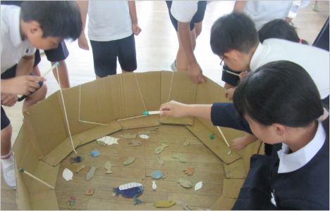 児童が企画した催し物の様子です。段ボールで自作した魚釣りゲームをしています。