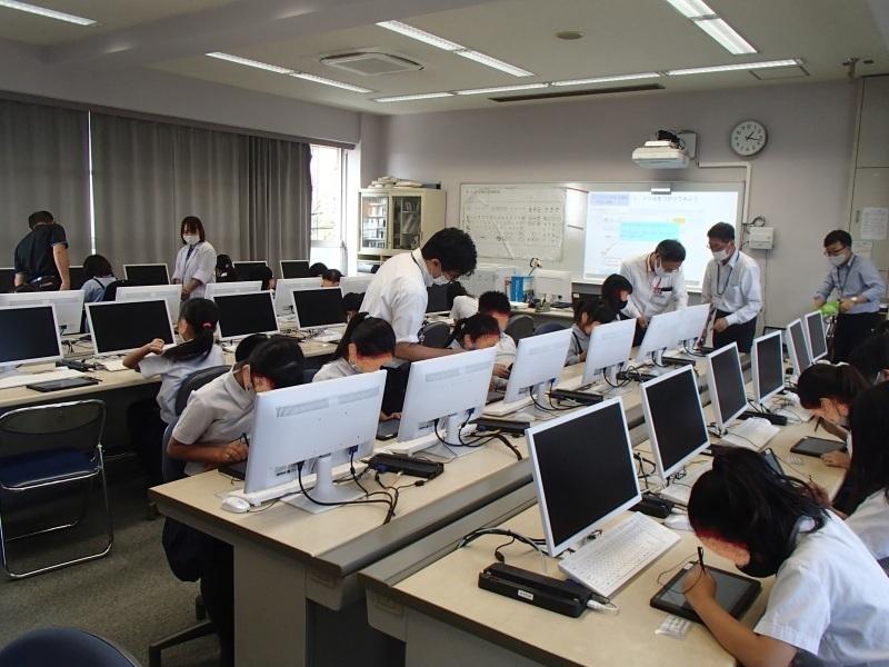 机にパソコンが並び、タブレットをペンタッチする学生の体験会の写真