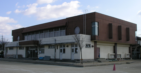2階部分が焦茶色で1階部分が白色の熊取北中学校の武道館の外観写真