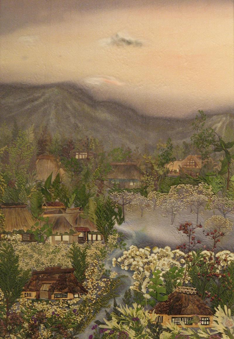 奥には山、手前には藁ぶきの屋根がある家や白い花、緑の葉のついた木などが描かれている作品