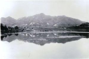 青池の湖畔に映し出された、土丸・雨山城の白黒写真