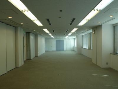 何も置かれていないフローリングと両側に白い壁がある会議室の室内の写真