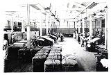 昭和初期に撮影された、機械や材料が置いてある操業当時の工場内部の白黒写真