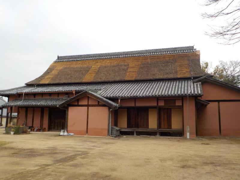 主屋の茅葺き屋根の差し茅作業が完了し、屋根に色違いの部分が見える主屋の写真