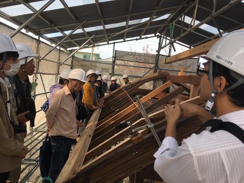 現地見学会にて屋根部分を見ている見学会参加者の方々の写真