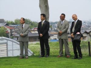 スーツの町長や、3名の男性が笑顔で横に並んでいる写真