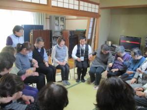 畳の部屋で参加者達と町長が円を囲むように椅子に座ってレクリエーションをしている写真