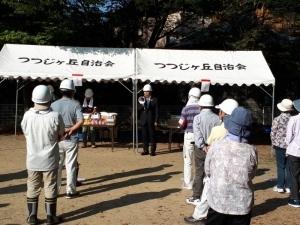 つつじヶ丘自治会と書かれたテントの前に立ち、拡声器で話をする町長、手前に参加者達が写っている写真