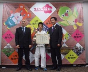 町民スポーツ賞を授与された空手着姿の甲田君を真ん中に3名で写した写真