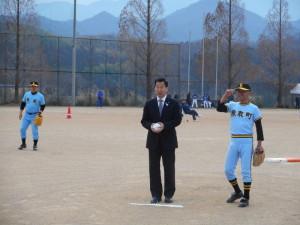 始球式で、スーツの町長が、ボールをもってマウンドに立っている写真