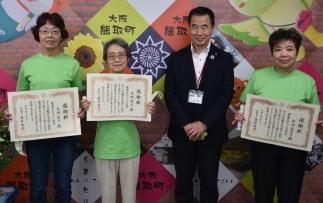 令和2年度高齢者いきいき地域活動表彰を受けた熊取町食生活改善推進協議会の方々が賞状を持って町長と共に撮影されている写真