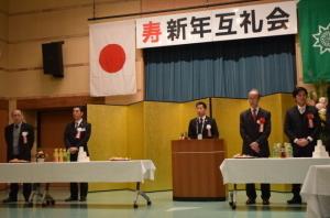 頭上には寿新年互礼会と文字があり、前に置かれた演説台で町長が話をしている写真