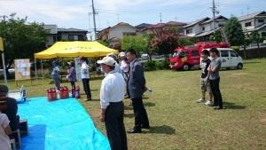 ブルーシートの前に立っている町長や、住民の写真