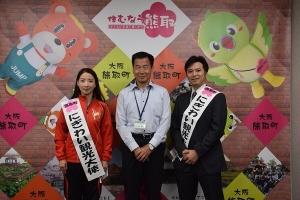 にぎわい観光大使のたすきをかけた渡邉俊哉さん、陳静さん、町長が並んでいる記念写真