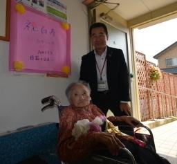 令和二年度で100歳になられた方が住んでいる場所に訪問して100歳になられた方との2ショットの写真を取っている町長の写真