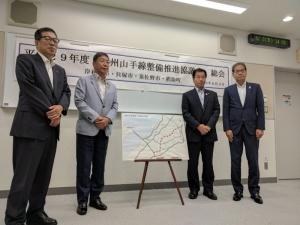 中央には地図が置かれていて、地図の両脇に熊取町長、貝塚市長、岸和田市長、佐野市副市長が並んでいる記念写真