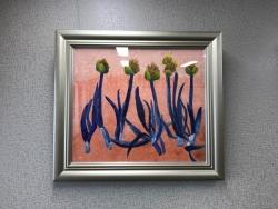 花は黄色く茎と葉が紫色の5本の花が描かれている絵が額縁に入れられ壁に飾られている写真