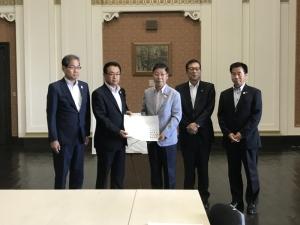 左から佐野市副市長、大阪府副知事、岸和田市長、貝塚市長、熊取町長が並んで立ち、竹内大阪府副知事と信貴岸和田市長が一緒に要望書を持っている写真