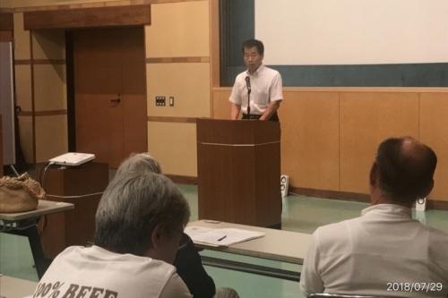 町長が演台の前に立ち、座っている参加者に向かって話をしている写真