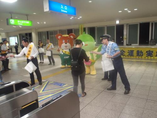 駅構内でチラシを配布する町長や警察官の写真