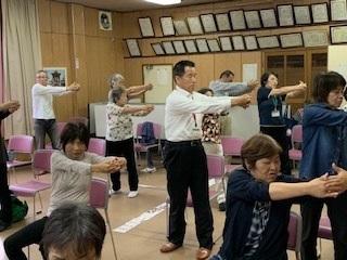 町長や参加者達が両手を組みながら腕を横に伸ばして運動をしている写真