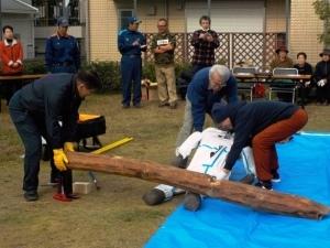 東和苑地区自主防災会訓練で木に挟まれた人の模型の救出訓練を行っている様子の写真