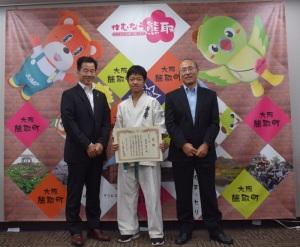 町民スポーツ賞授与で表彰された空手着姿の南出和志さんと男性2名が並んでいる写真