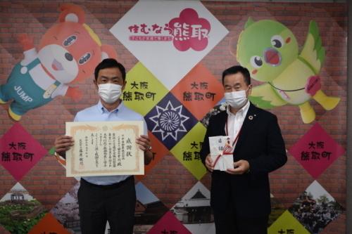 下中自動車株式会社 代表取締役 安芸幸司氏が感謝状を贈呈されている様子の写真