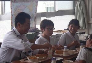 町長が、小学生と一緒に給食を食べている写真