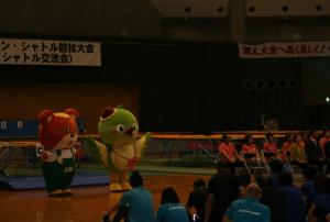 トランポリン・シャトル競技大会でジャンプくんとメジーナちゃんが挨拶をしている写真