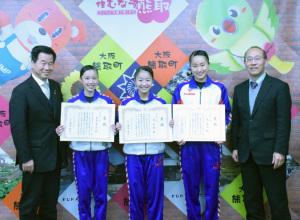 東真衣さん、南涼香さん、中島梨々花さんが賞状を持ち、左右に立つ町長と、男性が横に並んでいる記念写真