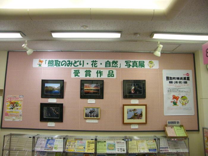 掲示板に展示された「熊取のみどり・花・自然」写真展の受賞作品の写真